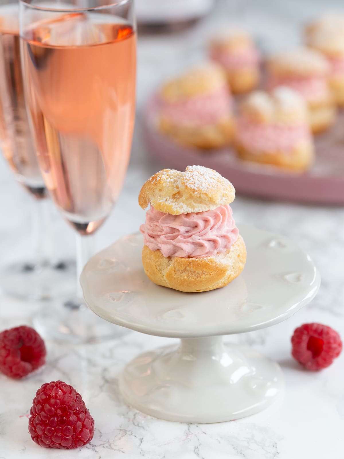 A single cream puff on a small cake stand.