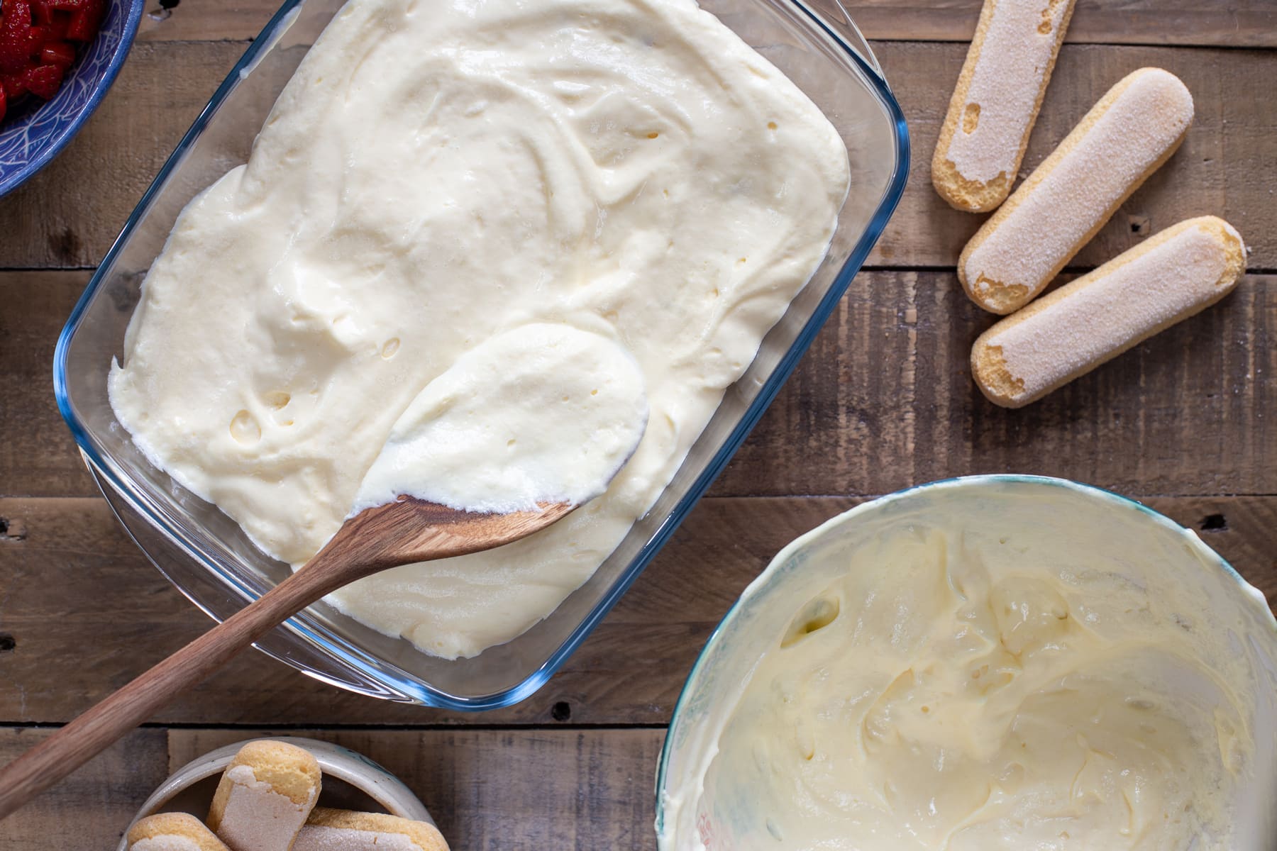 Spreading a layer of mascarpone cream over the strawberries.