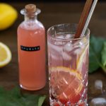 Rhubarb G&T next to a bottle of rhubarb syrup.