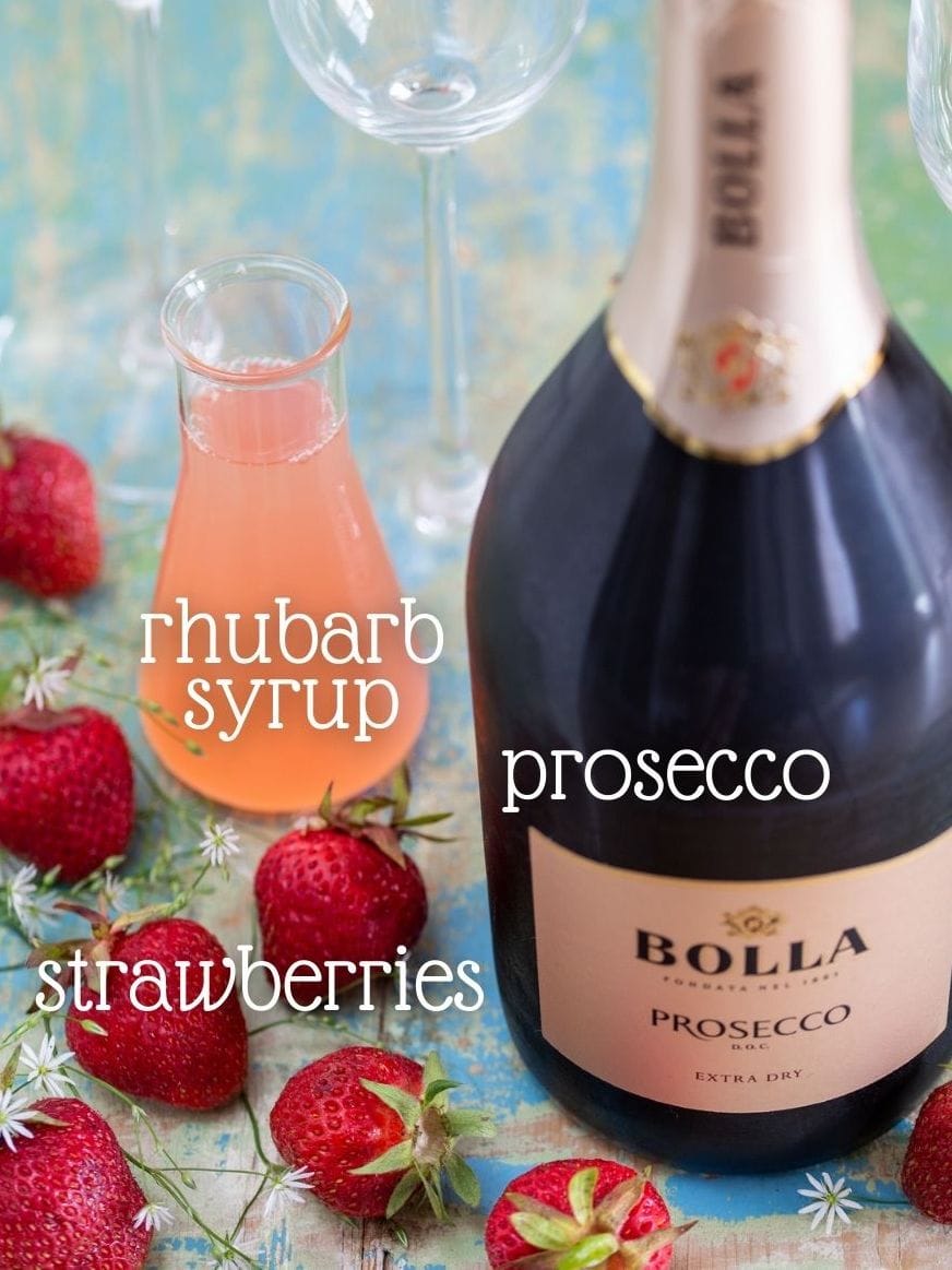 Fresh strawberries, syrup and a bottle of bubbels.