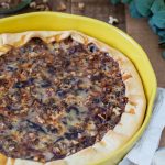 Baked quiche in a yellow tart pan.
