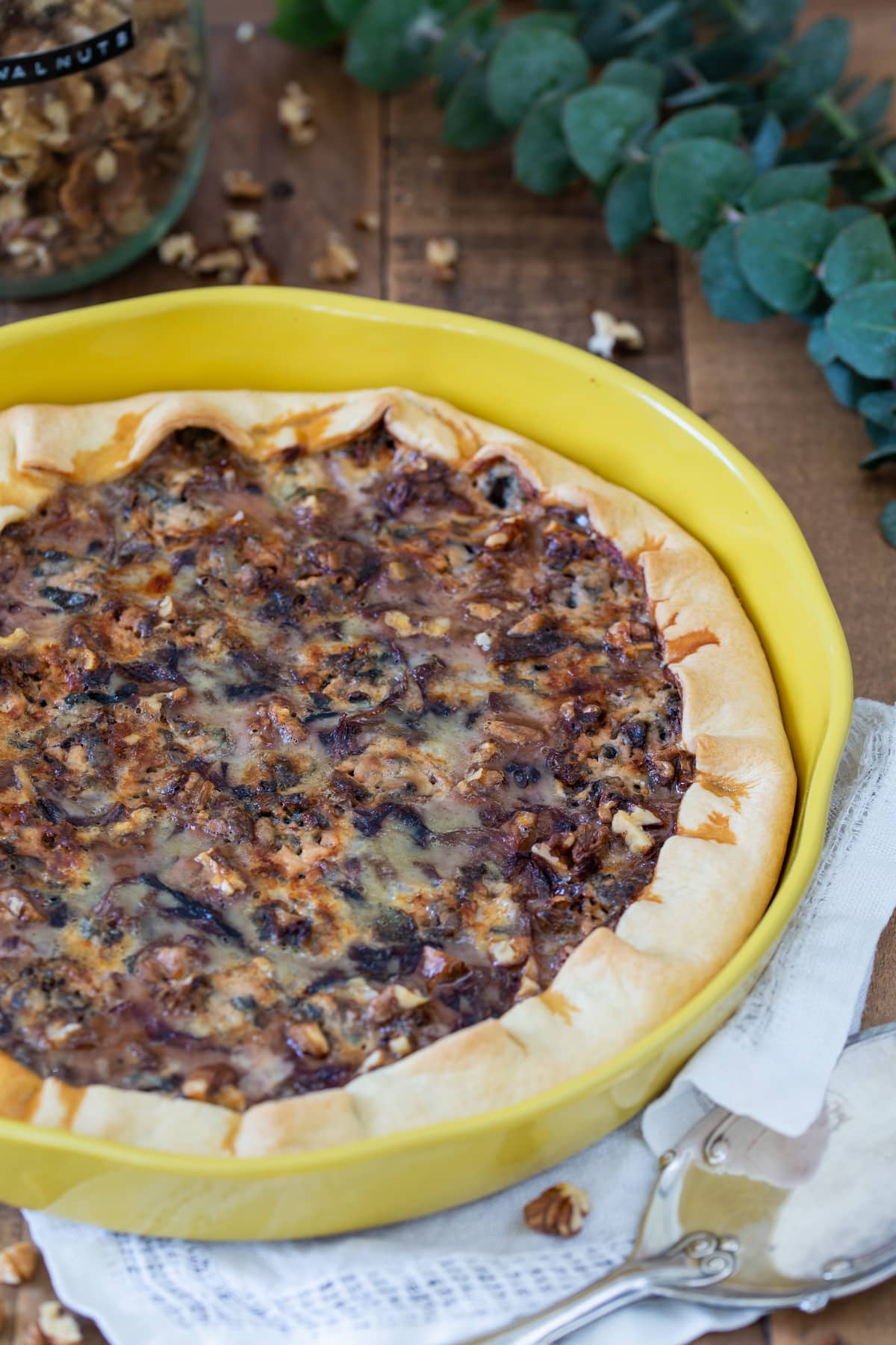 Baked quiche in a yellow tart pan.