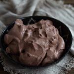 A batch of cocoa whipped cream in a black bowl.