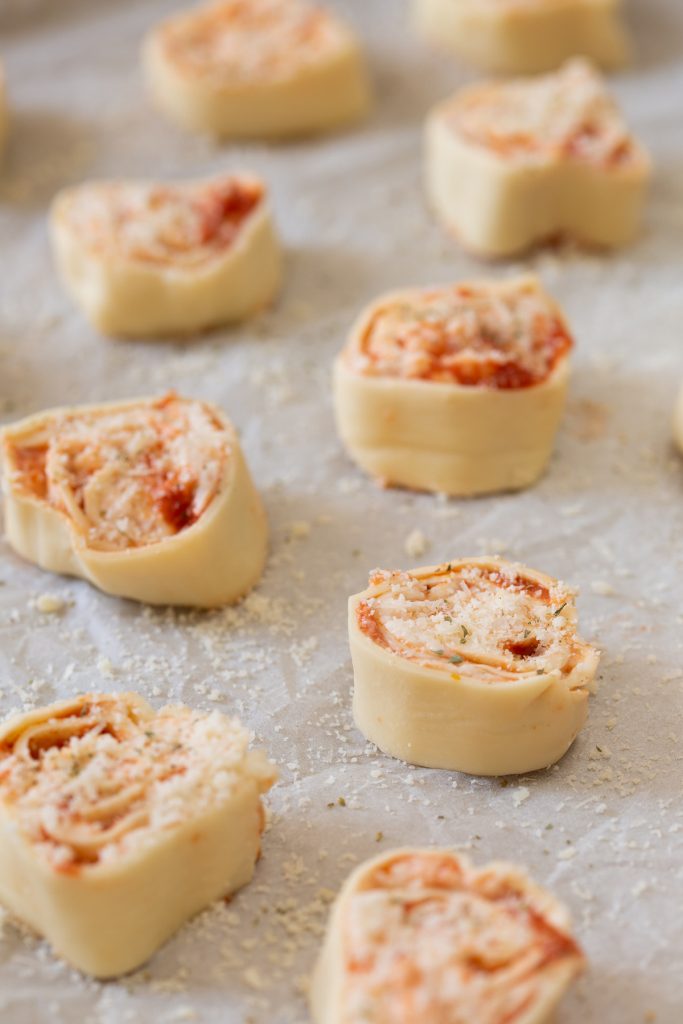 Unbaked puff pinwheels on baking paper.