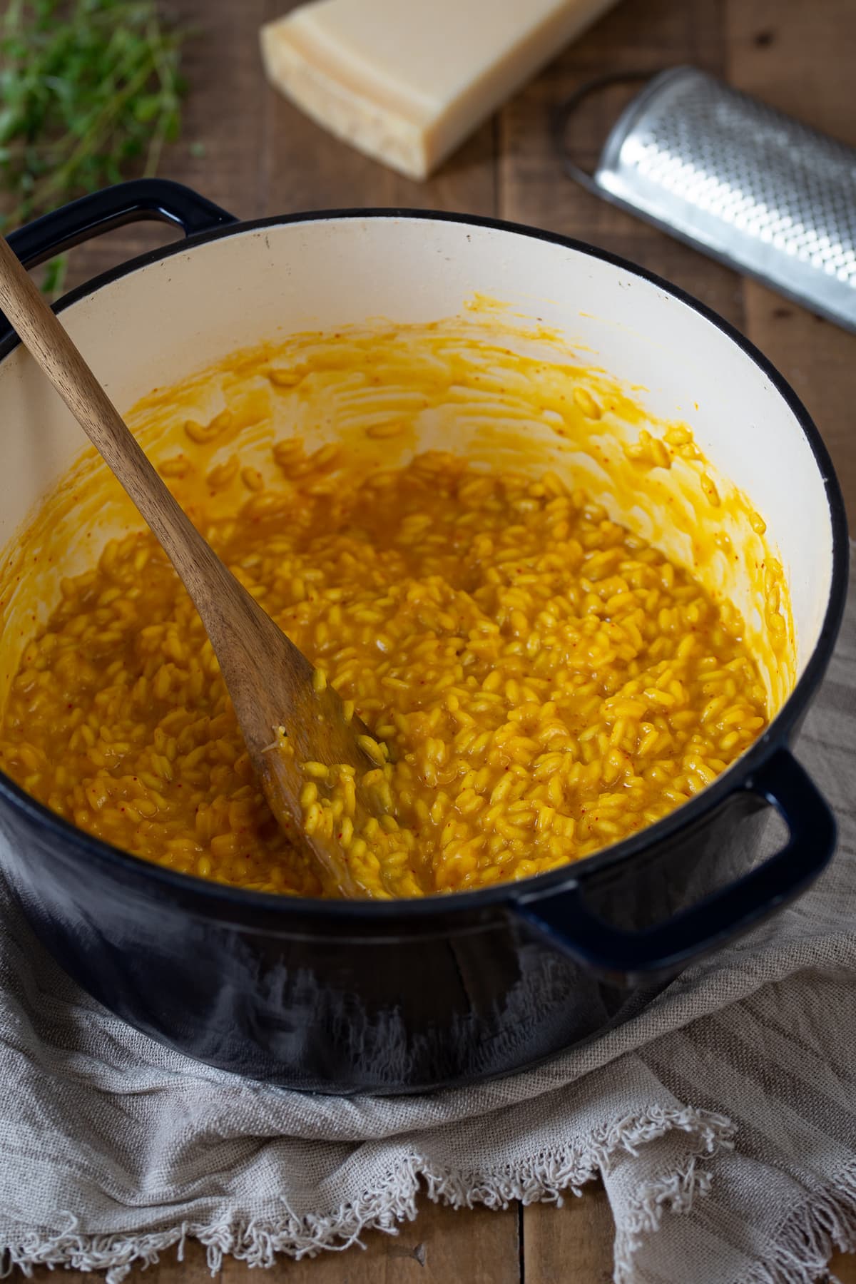 Yellow risotto in a Dutch oven pot.