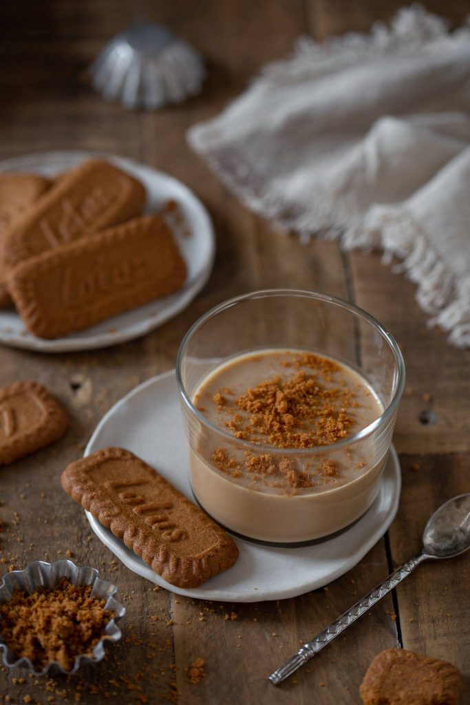 Biscoff panna cotta in a glass next to a Lotus cookie.