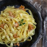 Chanterelle tagliatelle served on a black plate.