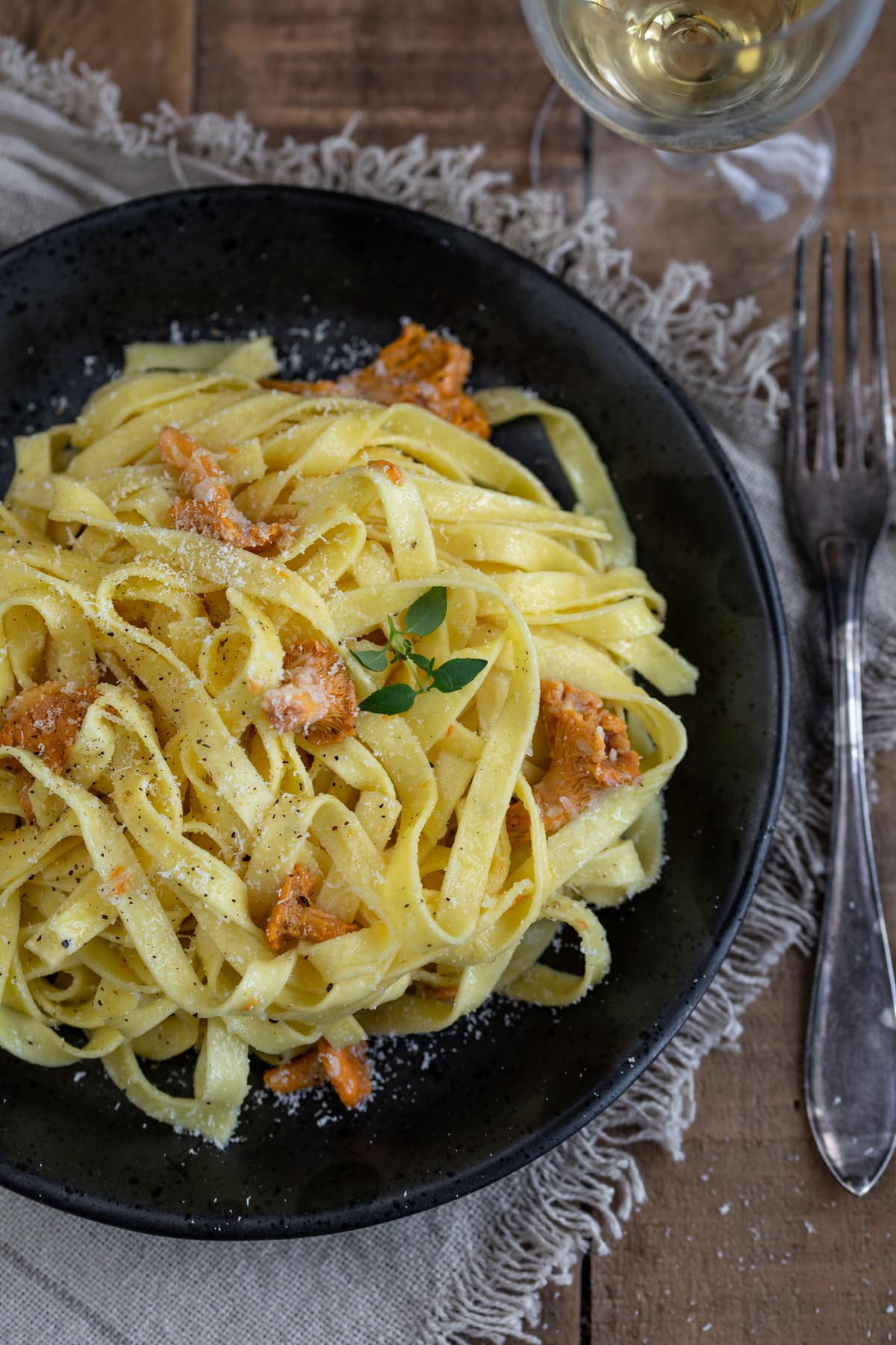Chanterelle tagliatelle served on a black plate.