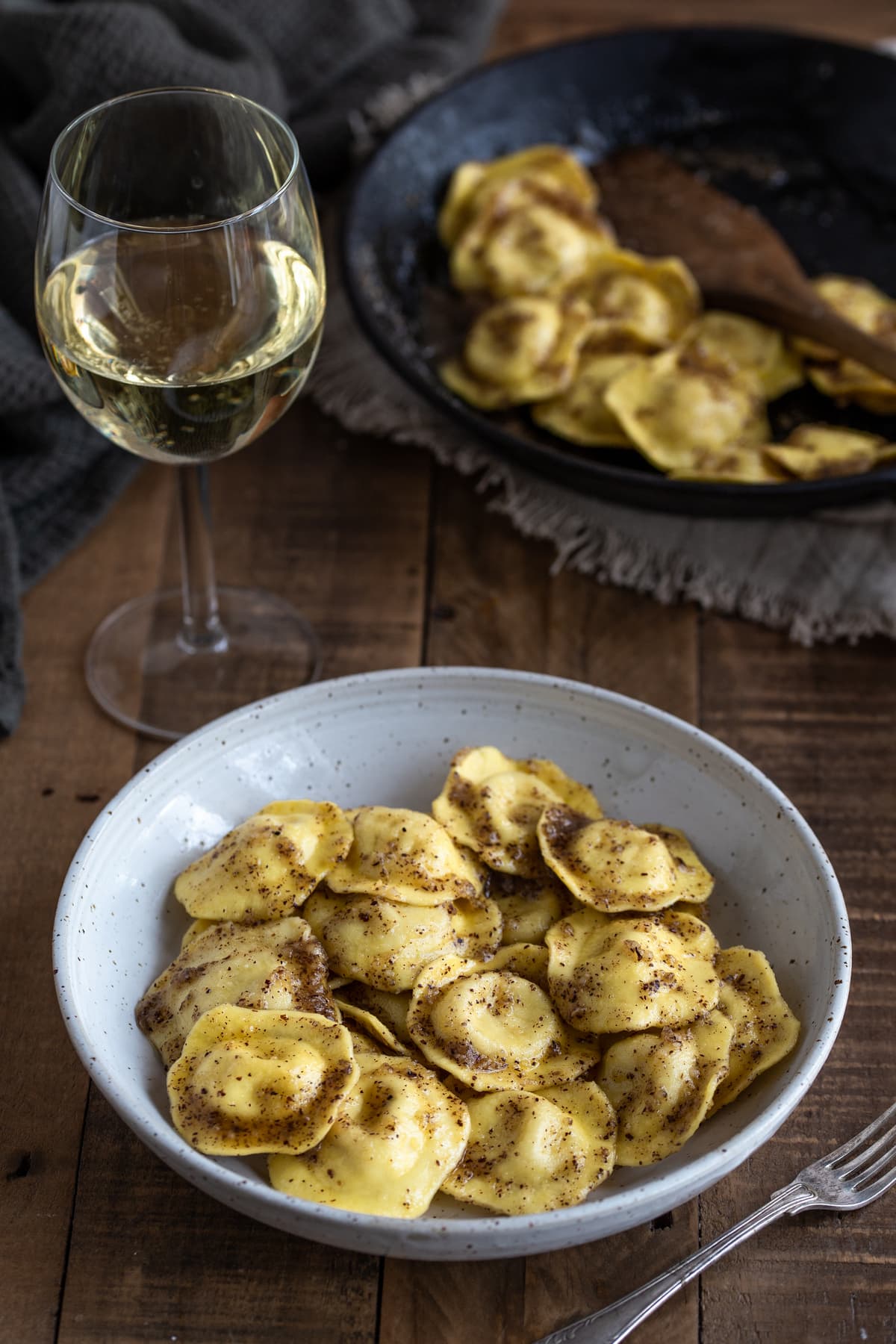 A portion of cheese ravioli with hazelnut butter in a white bowl.