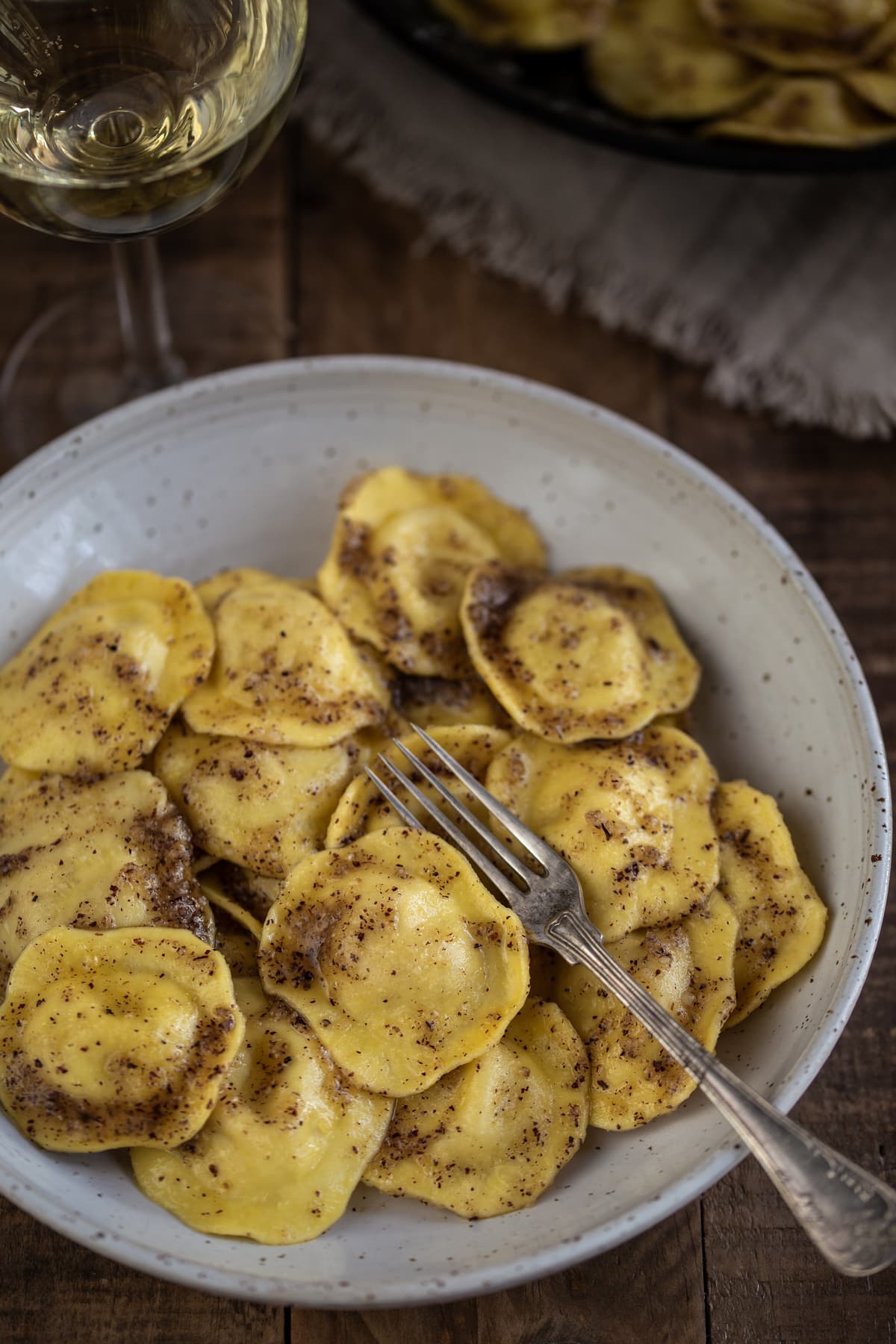 A portion of ravioli in a white bowl.