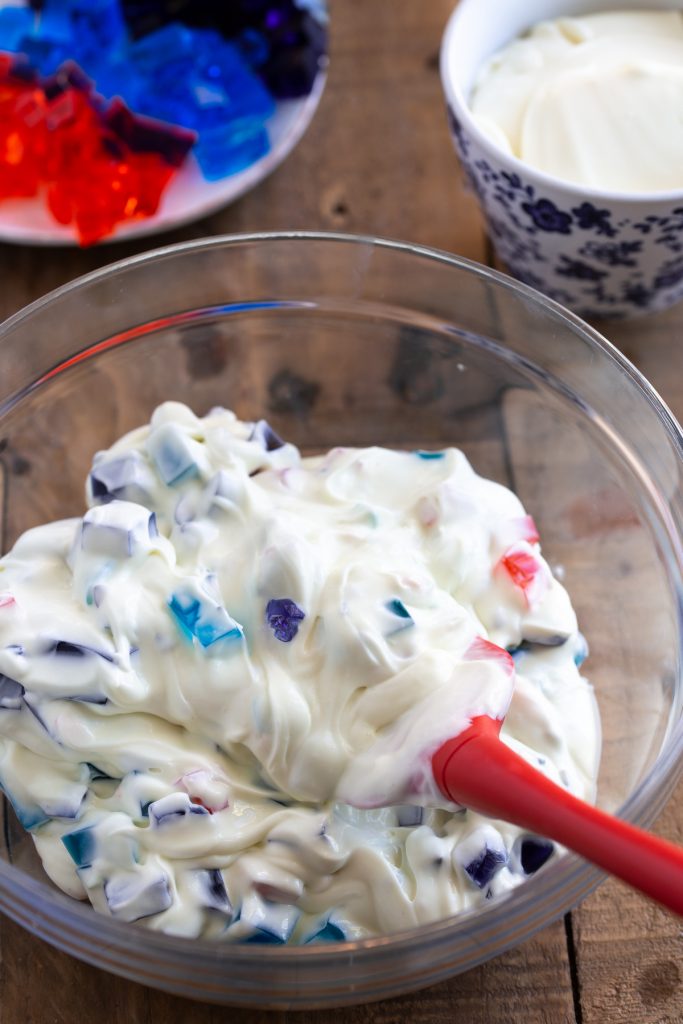 Folding in diced jello into cake filling.
