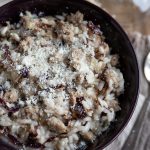 A portion of risotto in a dark purple bowl.