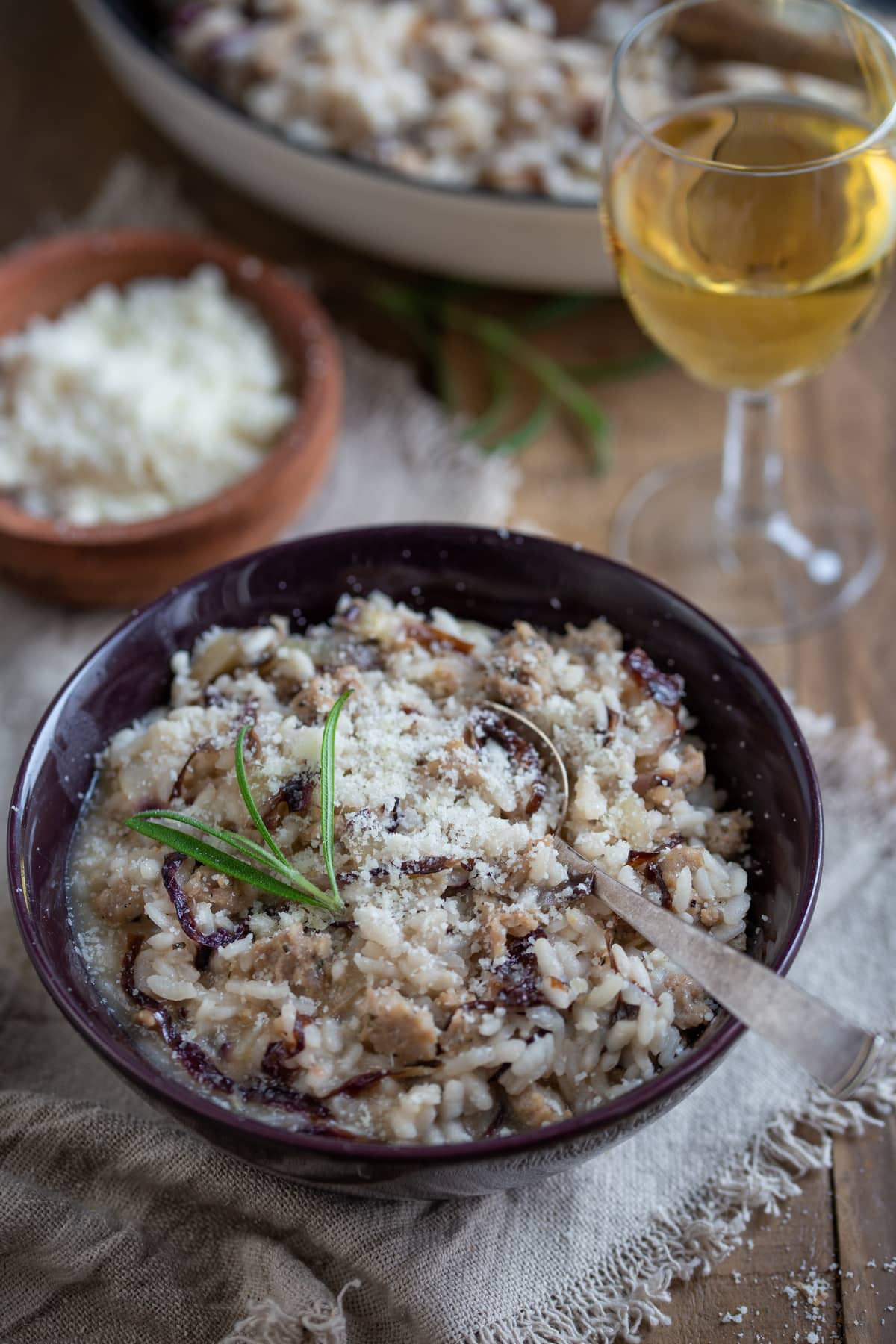 A portion of risotto in a dark purple bowl.
