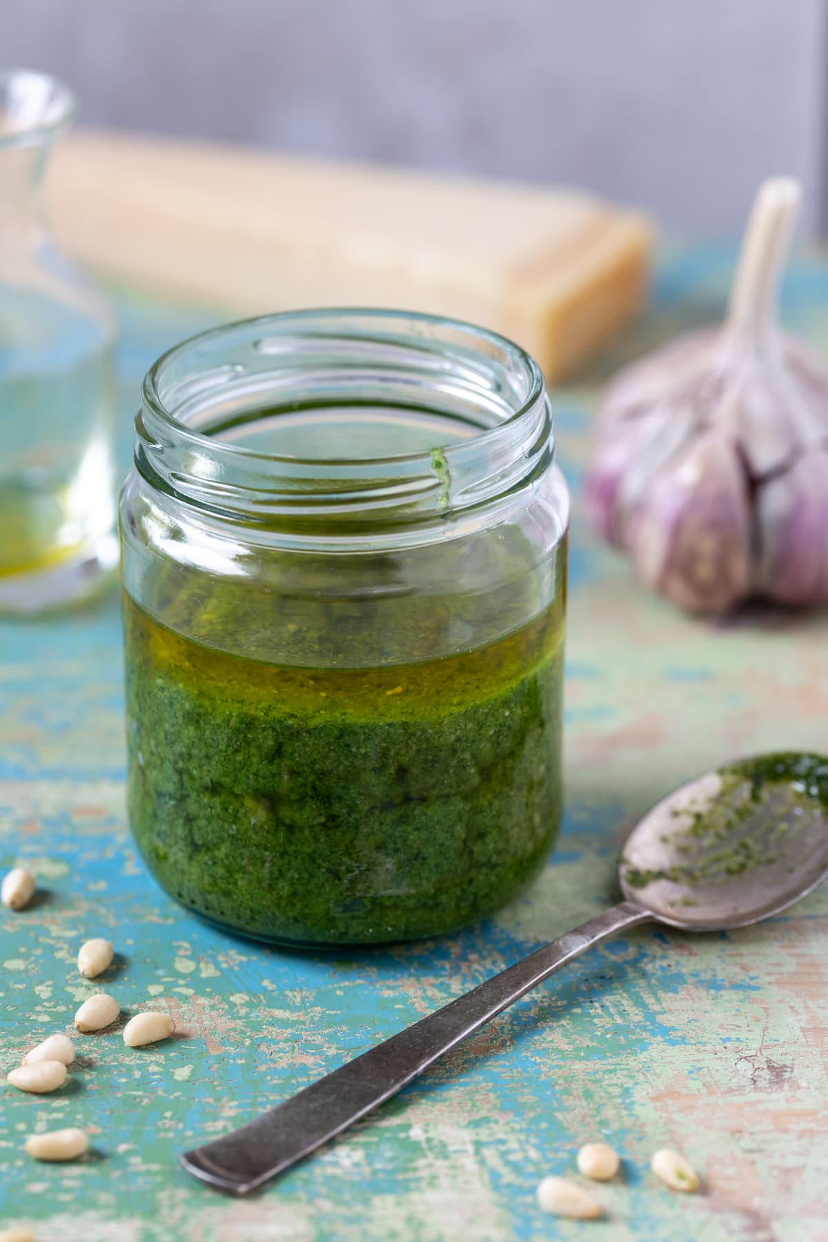 A jar of basil pesto topped with olive oil.