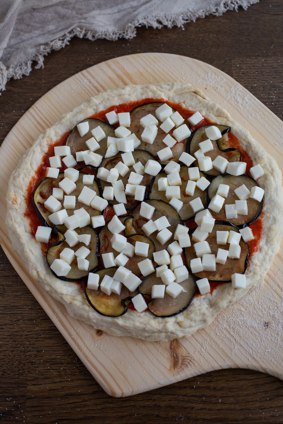 Uncooked pizza on pizza peel.