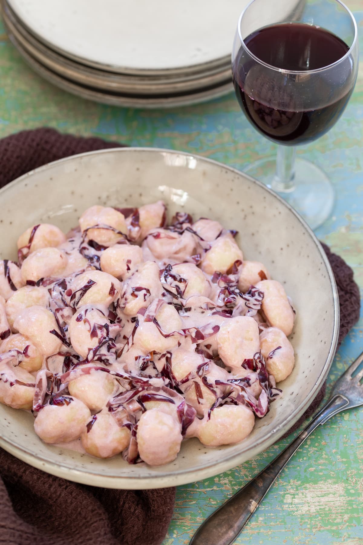 Gnocchi radicchio e panna served in a beige bowl.