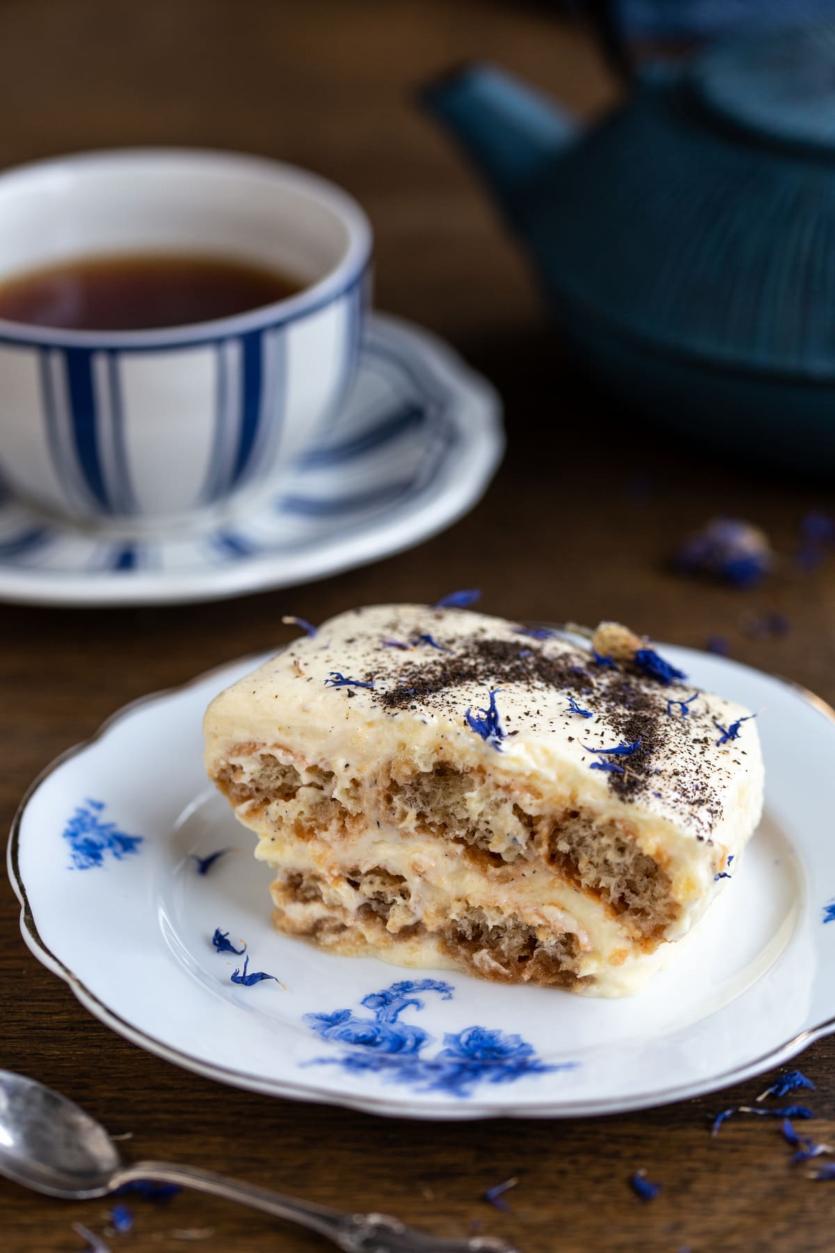 A portion of tiramisu on a white and blue plate.