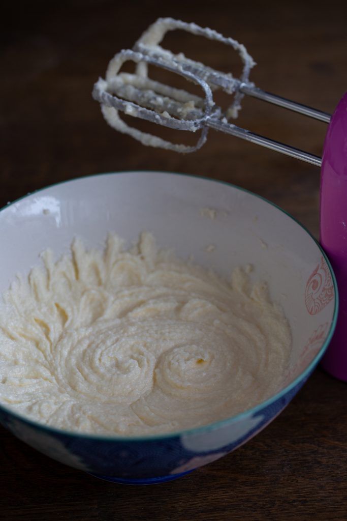 First stage of batter preparation to show soft texture of butter, sugar and oil mixture.
