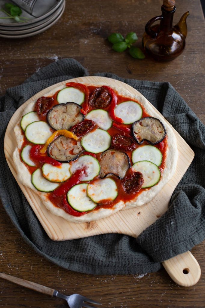 Uncooked pizza on a pizza peel.