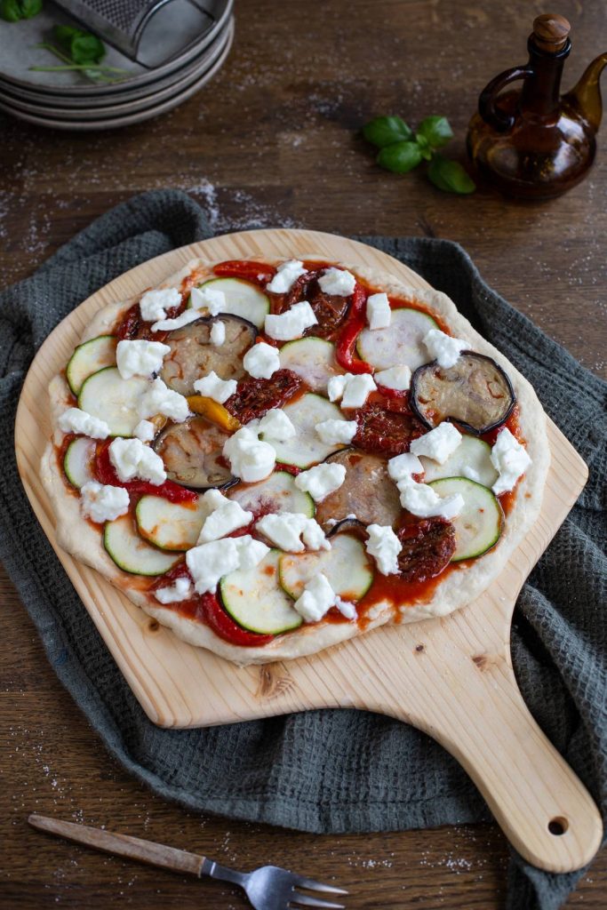 Uncooked pizza on a pizza peel.