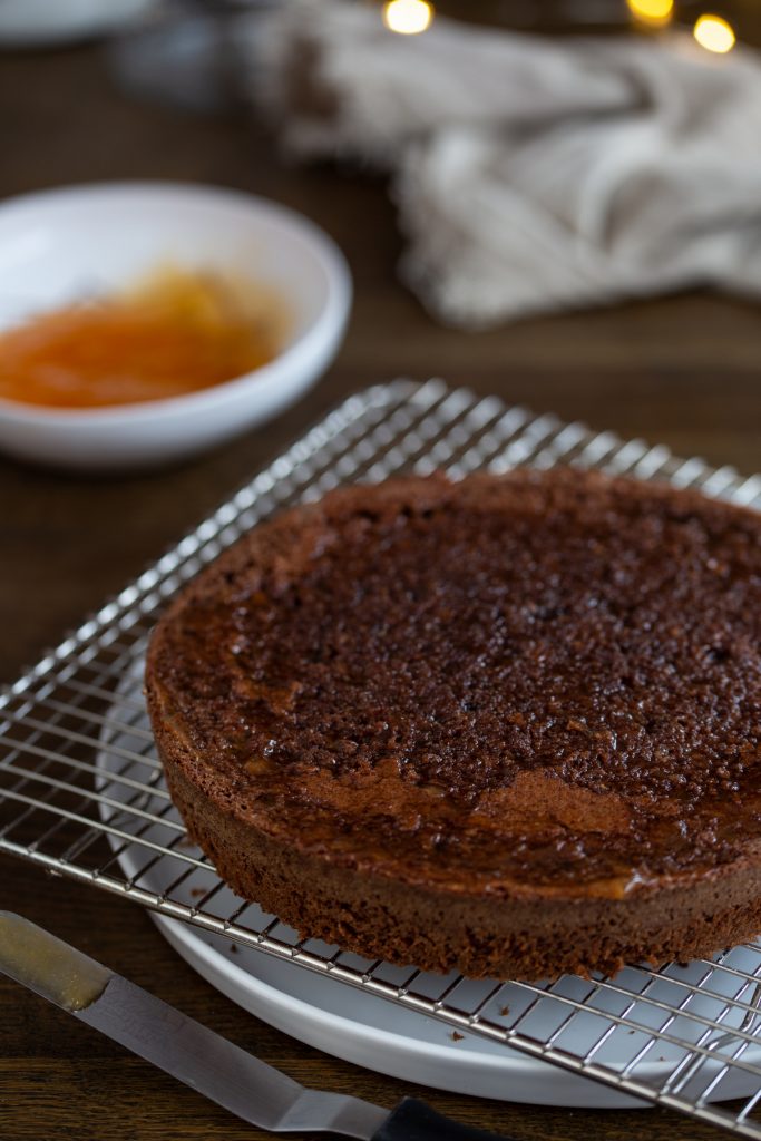 Spreading apricot jam on one layer of chocolate cake.
