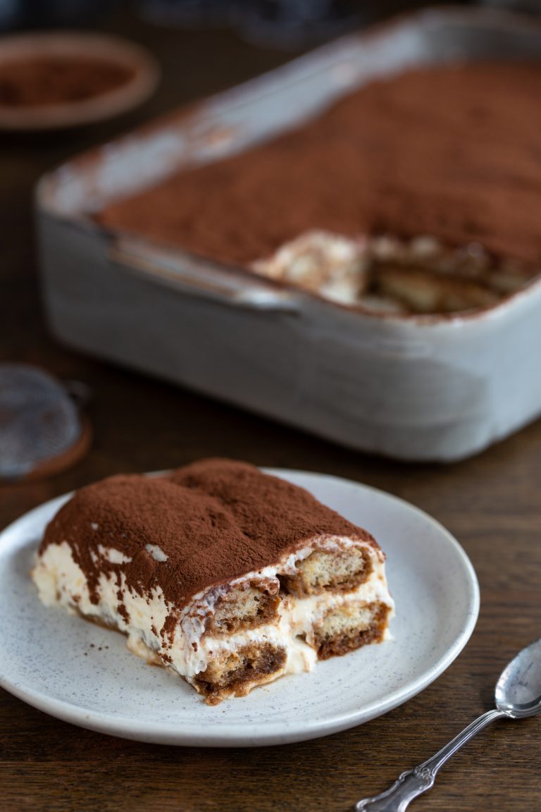 A serving of classic tiramisu on a white plate.