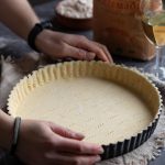 Homemade pie crust pressed onto a baking tin.