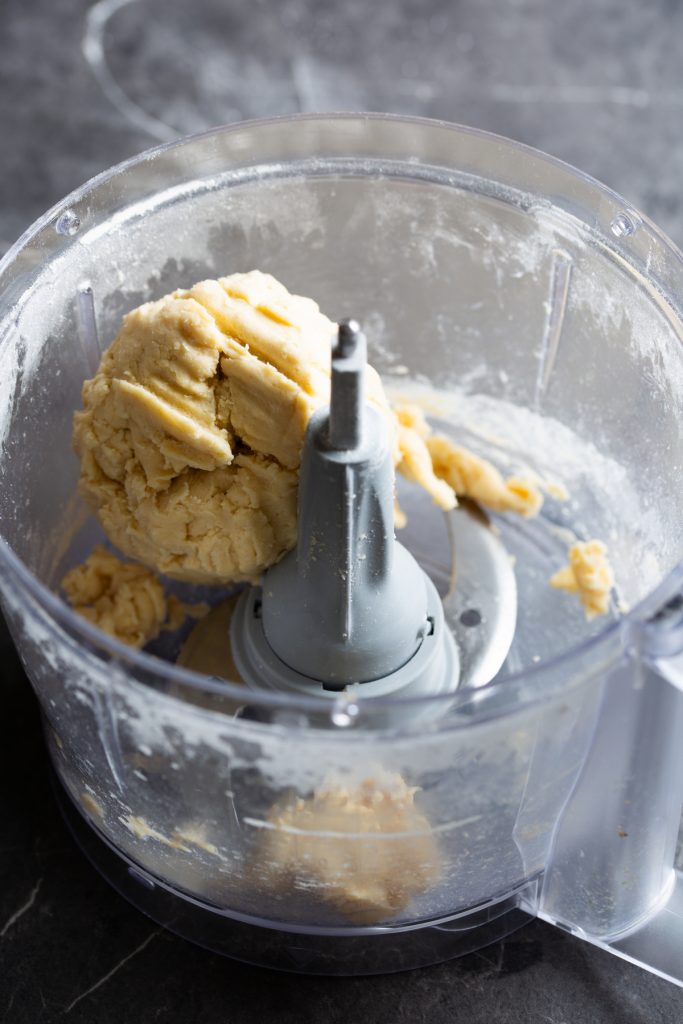 Inside of a food processor showing ball of dough.