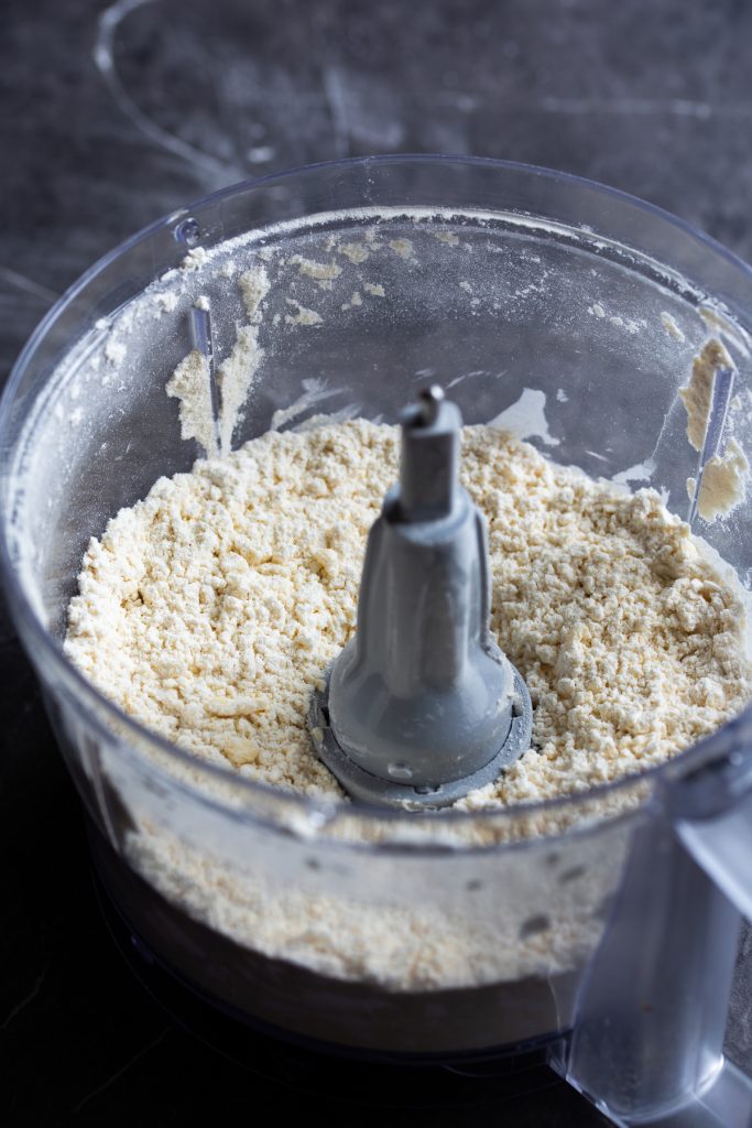 Inside of a food processor showing coarse crumbs.