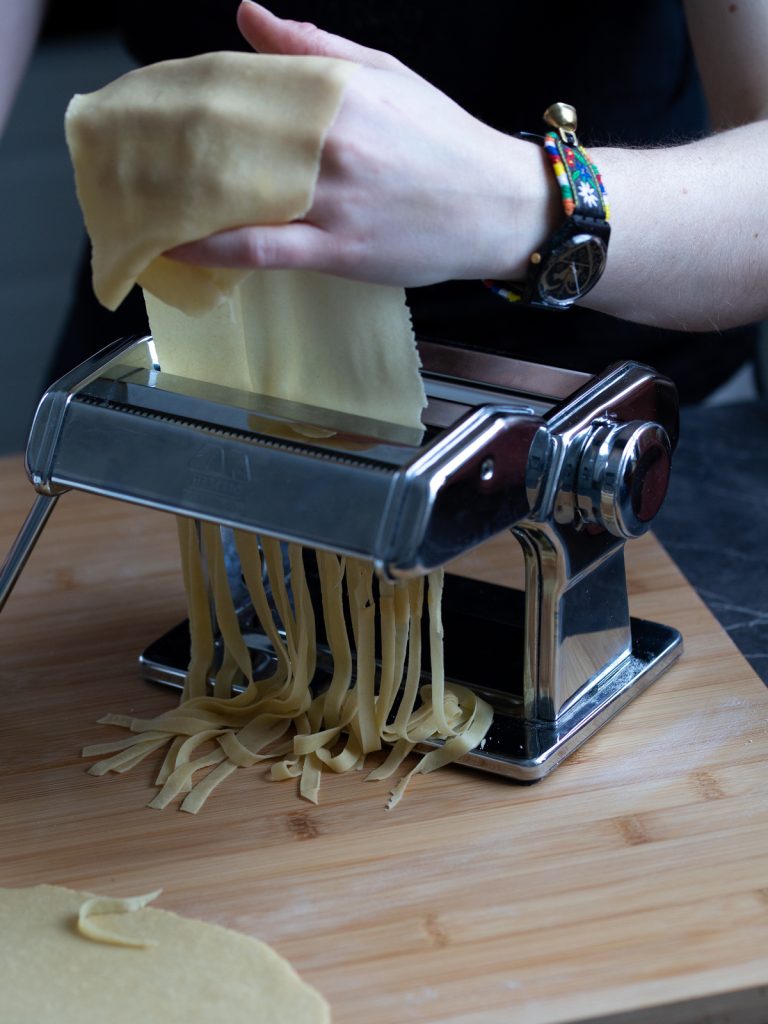Making fettuccine in a pasta machine.