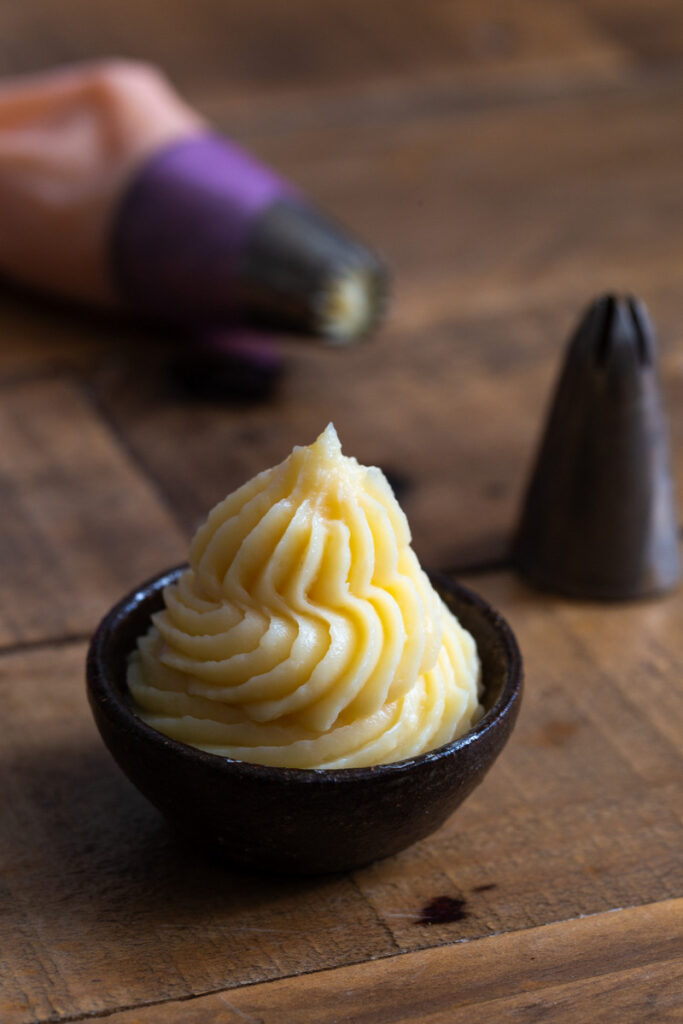 Vanilla custard piped into a small bowl.