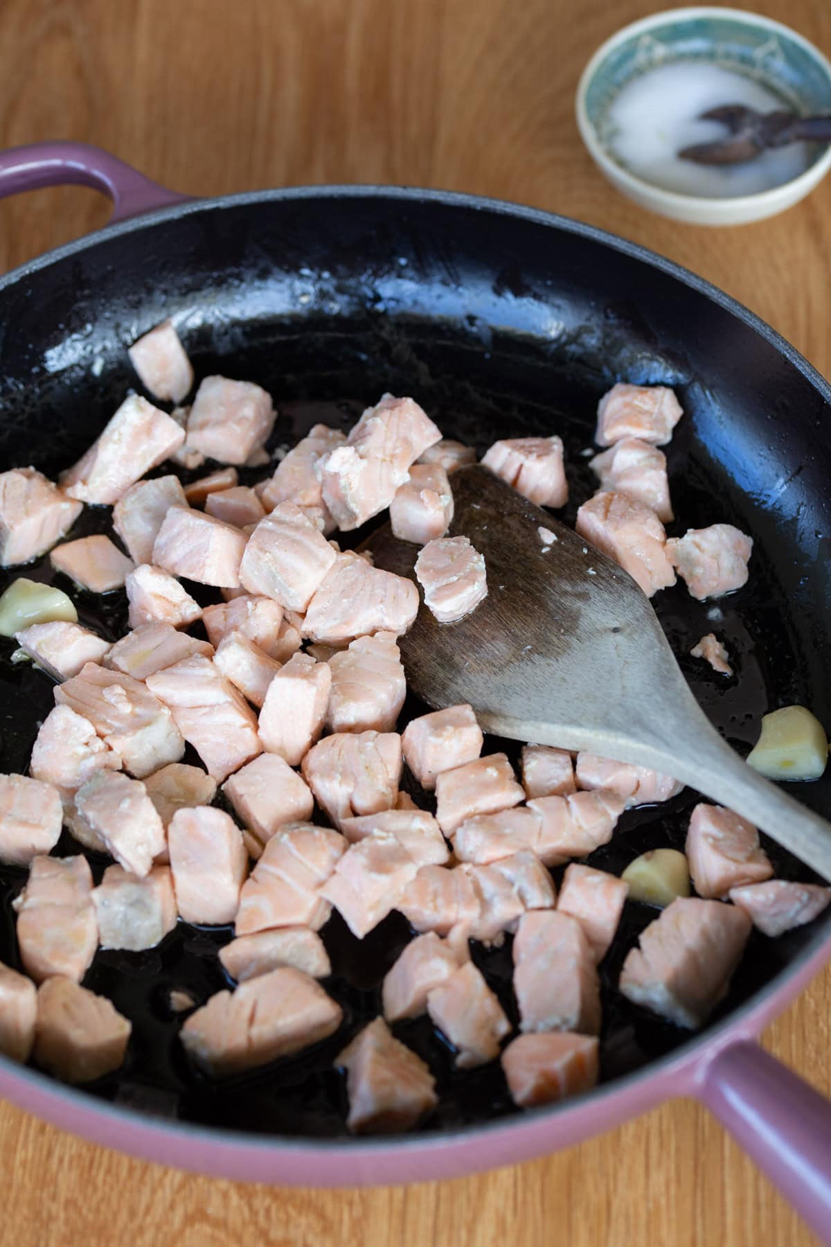 Salmon sauteed in a skillet.