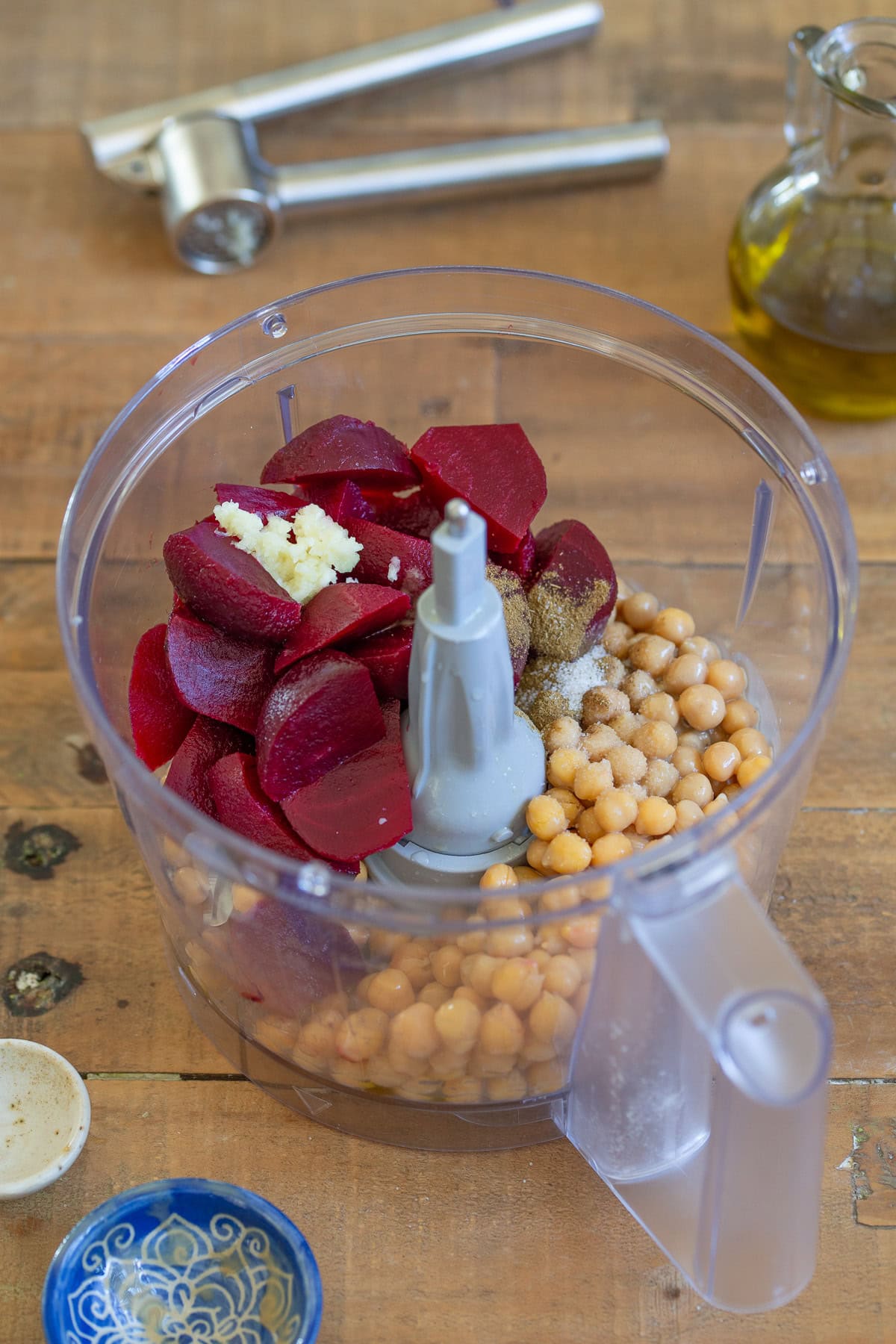 Beets, chickpeas and other ingredients added to a food processor.